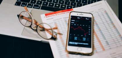 A detailed look at financial tools including a smartphone and laptop for stock analysis.