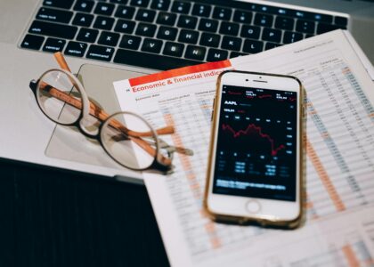 A detailed look at financial tools including a smartphone and laptop for stock analysis.